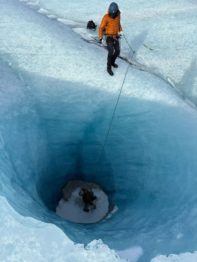 A guy at the bottom of a deep ice hole